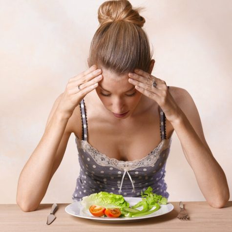 Young woman looking at plate of salad