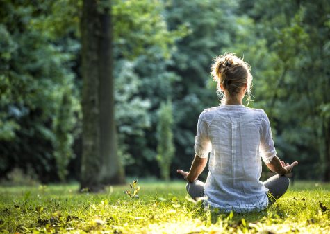 Young blonde woman meditating in the park